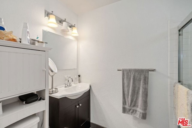 bathroom with vanity, toilet, and a shower with shower door