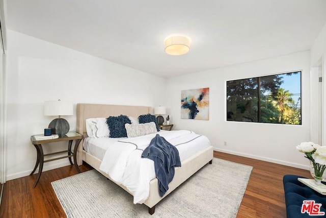 bedroom with dark hardwood / wood-style floors