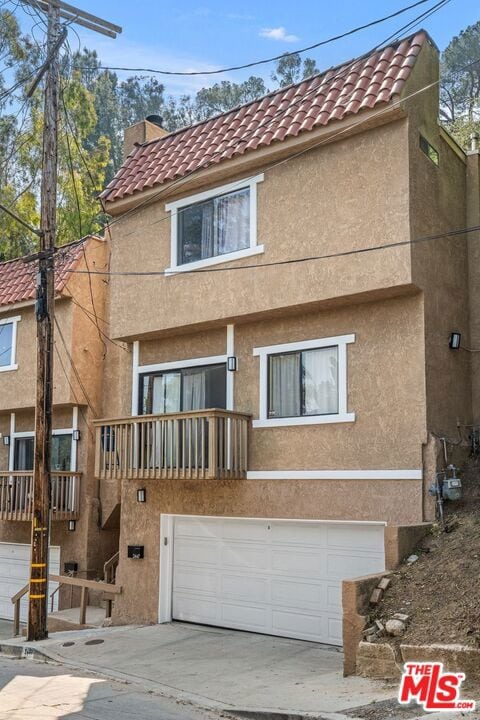 view of front of house with a garage and a balcony