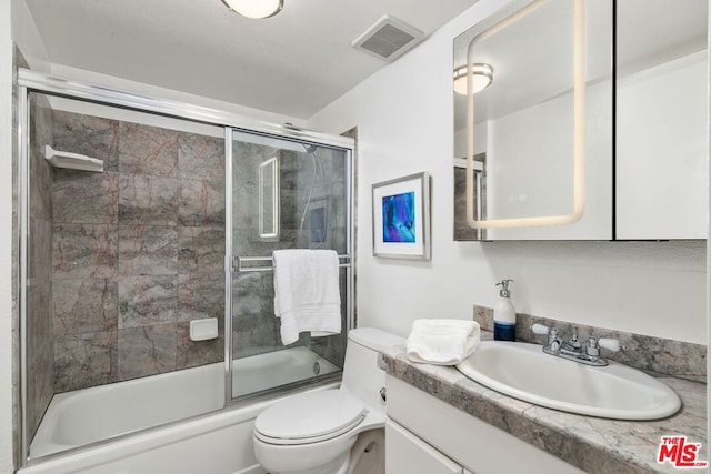 full bathroom with shower / bath combination with glass door, vanity, and toilet