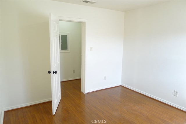 spare room with dark hardwood / wood-style floors