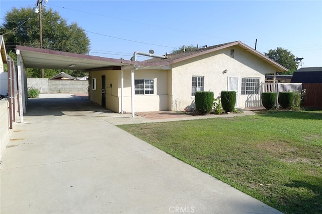 single story home featuring a carport and a front lawn