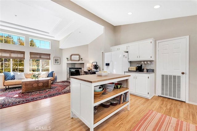 1169 Aztec, Topanga, CA 90290 - kitchen with white fridge with ice dispenser, open floor plan, open shelves, white cabinetry, and light wood-style flooring