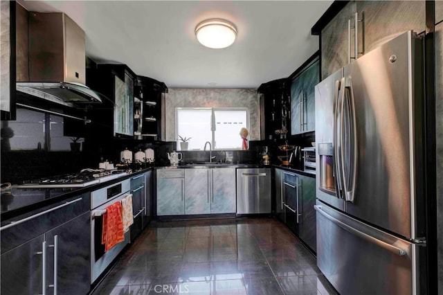 kitchen with sink, wall chimney range hood, stainless steel appliances, and tasteful backsplash