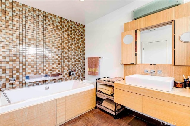 bathroom featuring vanity and tiled bath