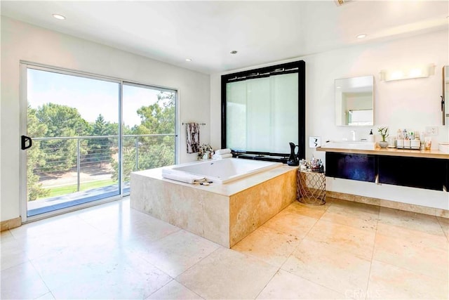 bathroom featuring vanity and tiled bath