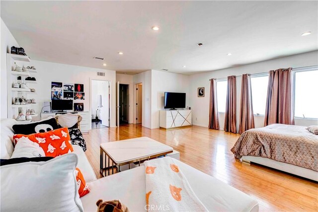 bedroom with light hardwood / wood-style flooring and multiple windows