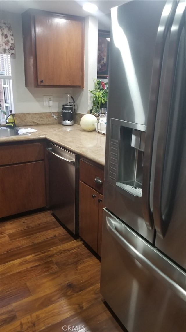 kitchen with appliances with stainless steel finishes and dark hardwood / wood-style floors