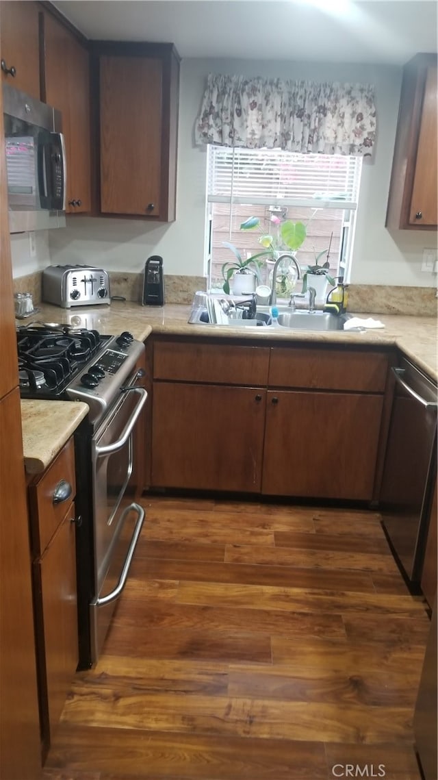 kitchen with dark hardwood / wood-style flooring, sink, and stainless steel appliances