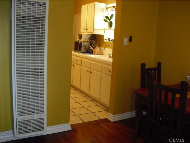 kitchen featuring light hardwood / wood-style flooring, white cabinetry, and sink