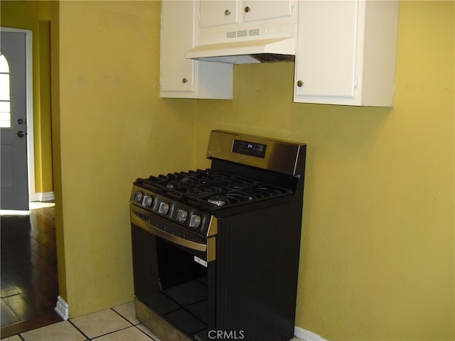 kitchen with light tile patterned flooring, black gas stove, and white cabinetry