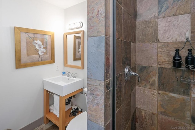 bathroom featuring a tile shower and toilet