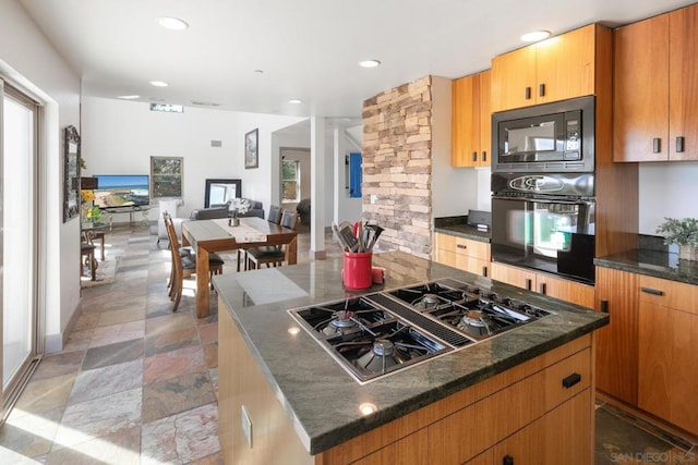 kitchen with black appliances, dark stone countertops, and a center island