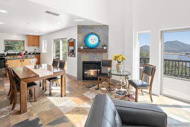 dining space with a mountain view, a fireplace, and sink