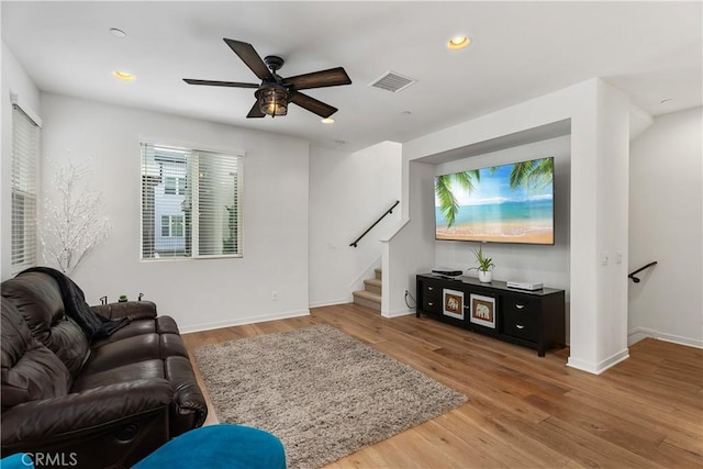 living room with wood-type flooring and ceiling fan