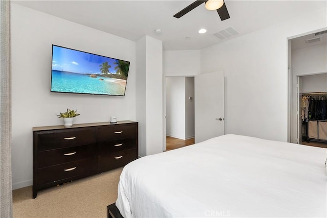 bedroom featuring ceiling fan, light carpet, and a closet