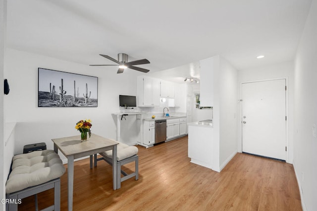 dining area with light hardwood / wood-style floors, ceiling fan, and sink