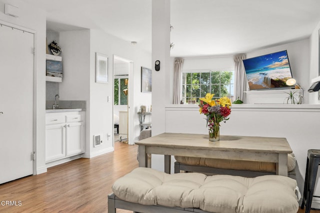 dining room featuring wood-type flooring and sink