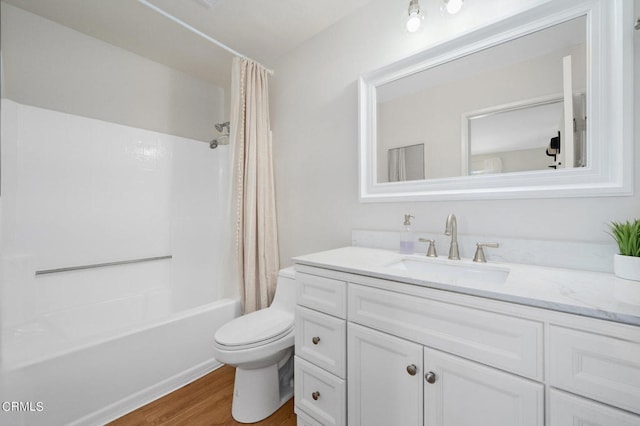 full bathroom with shower / bath combination with curtain, hardwood / wood-style floors, vanity, and toilet