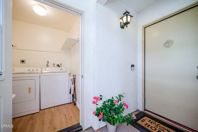 clothes washing area featuring light hardwood / wood-style floors and separate washer and dryer