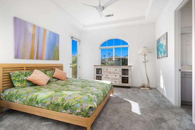 bedroom featuring connected bathroom, ceiling fan, a raised ceiling, and carpet floors