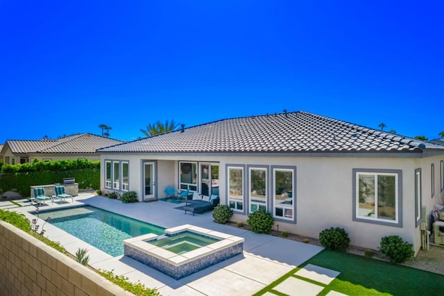 rear view of property featuring a patio and a pool with hot tub