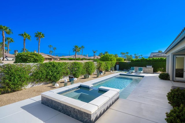 view of pool featuring a patio and an in ground hot tub