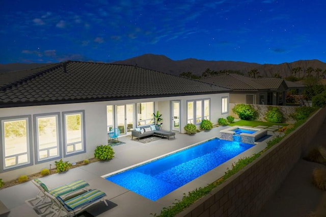 view of swimming pool featuring an in ground hot tub, a patio area, a mountain view, and an outdoor hangout area