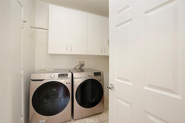 laundry room featuring cabinets, separate washer and dryer, and light tile patterned floors