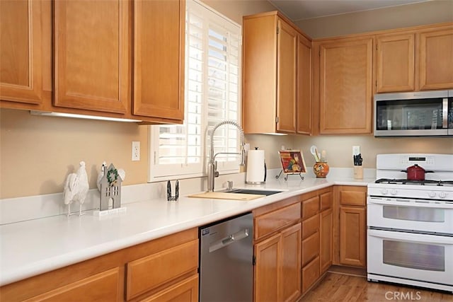 kitchen featuring sink, stainless steel appliances, and light wood-type flooring