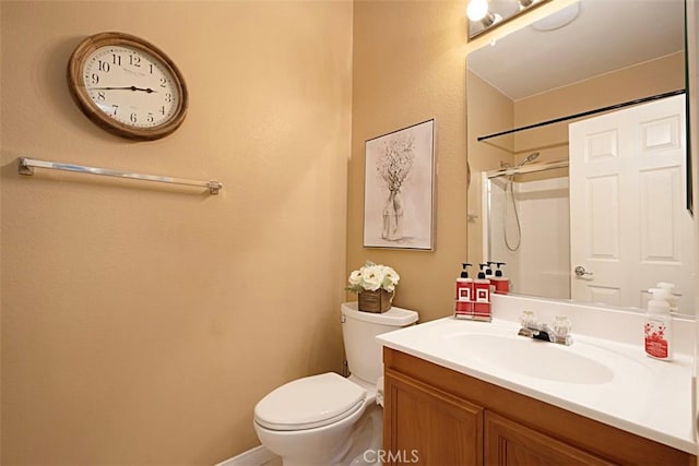 bathroom featuring a shower, vanity, and toilet