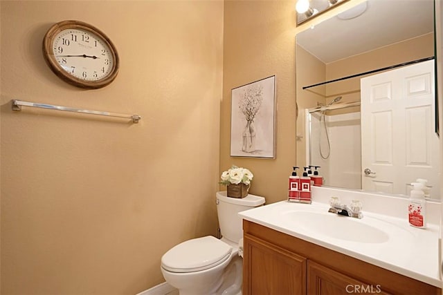 bathroom featuring toilet, vanity, and walk in shower