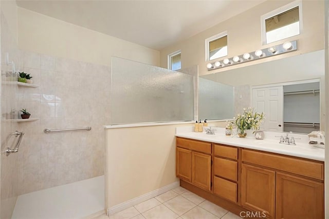 bathroom featuring tile patterned floors, vanity, and a tile shower