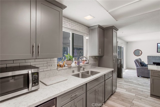 kitchen featuring light hardwood / wood-style flooring, gray cabinets, tasteful backsplash, and sink