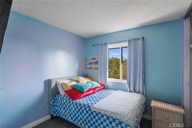 bedroom featuring a textured ceiling and dark hardwood / wood-style flooring