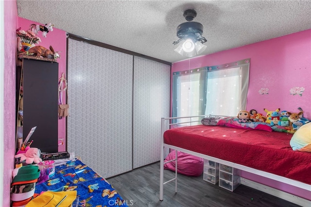 bedroom featuring a closet, a textured ceiling, and dark hardwood / wood-style flooring