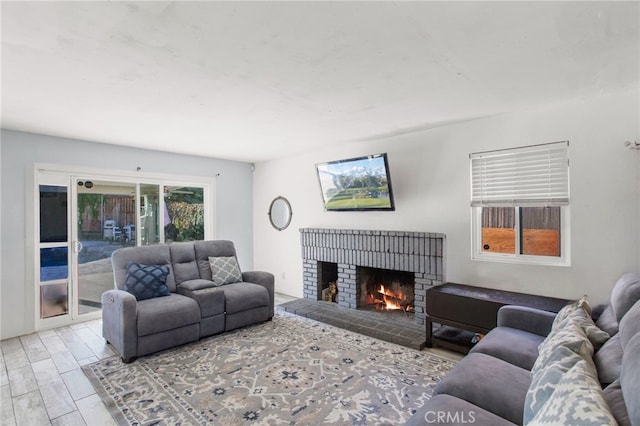 living room featuring light hardwood / wood-style floors and a brick fireplace