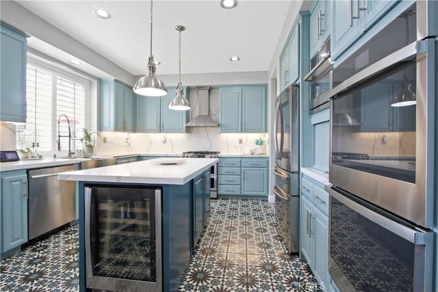 kitchen with a kitchen island, beverage cooler, backsplash, stainless steel appliances, and wall chimney range hood