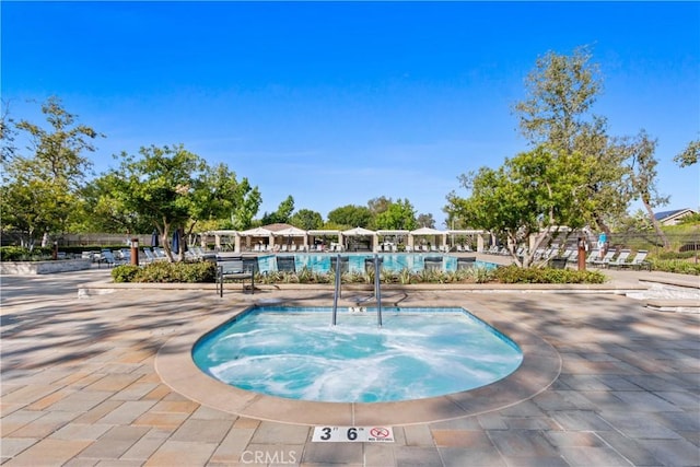 view of swimming pool with a patio and a community hot tub