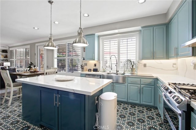 kitchen with blue cabinetry, sink, hanging light fixtures, appliances with stainless steel finishes, and a kitchen island