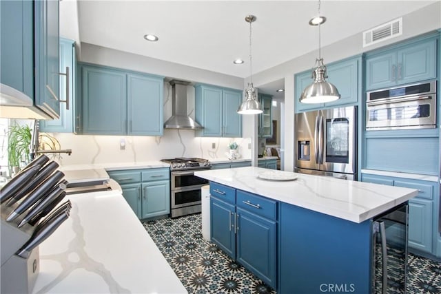 kitchen with a kitchen island, a breakfast bar, blue cabinets, stainless steel appliances, and wall chimney range hood