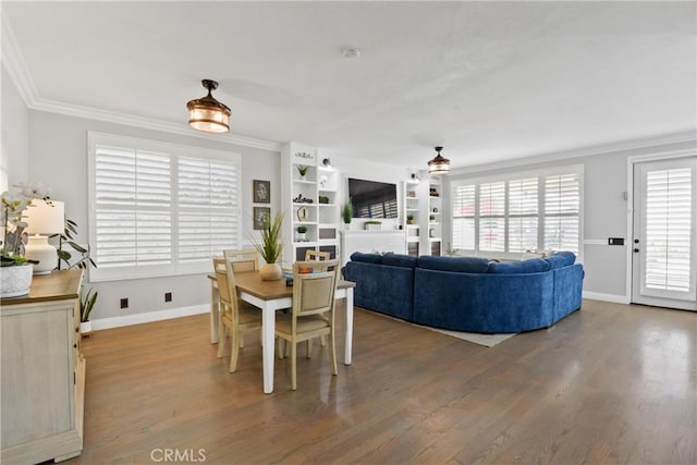 dining room with crown molding, wood-type flooring, and built in features