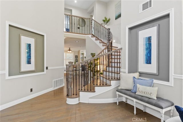 foyer entrance featuring hardwood / wood-style flooring and a towering ceiling