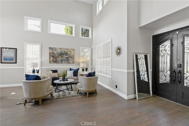 entryway with a towering ceiling, dark hardwood / wood-style floors, and french doors