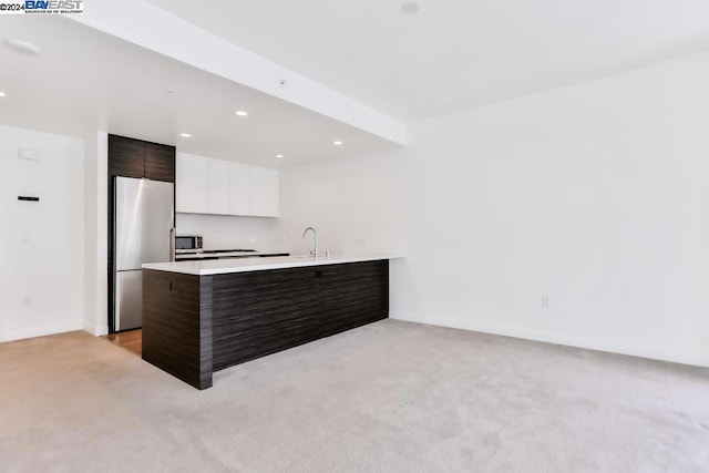 kitchen with white cabinets, light carpet, dark brown cabinetry, and stainless steel appliances