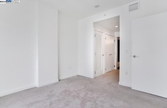 spare room featuring light colored carpet