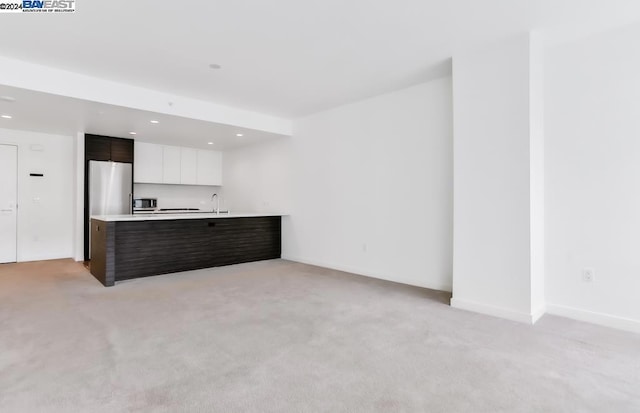 interior space with white cabinetry, dark brown cabinets, light carpet, and appliances with stainless steel finishes