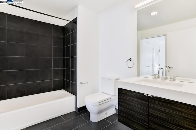 full bathroom with tile patterned floors, tiled shower / bath, vanity, and toilet