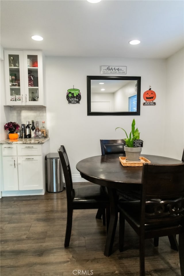 dining area with bar area and dark hardwood / wood-style floors