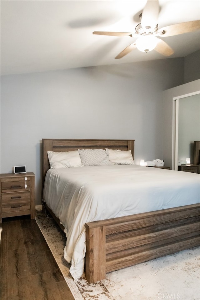 bedroom with dark hardwood / wood-style flooring and ceiling fan